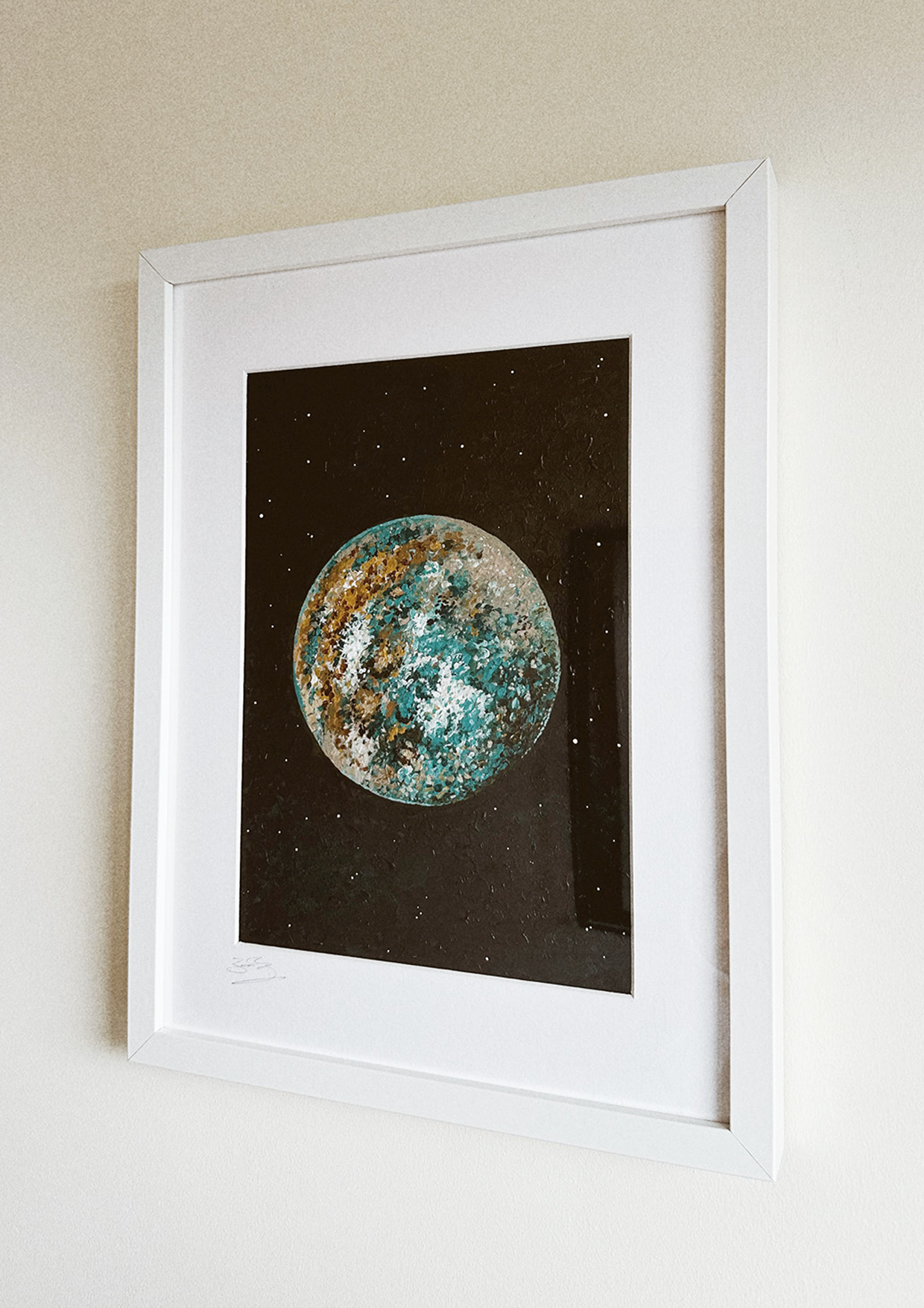Abstract paint in blues and oranges in frame on a white wall