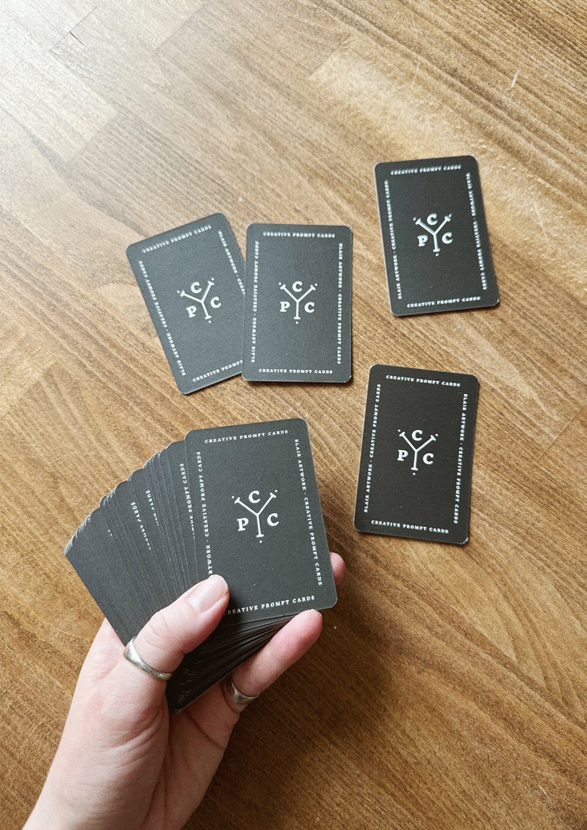 Hand holding cards on a wooden surface