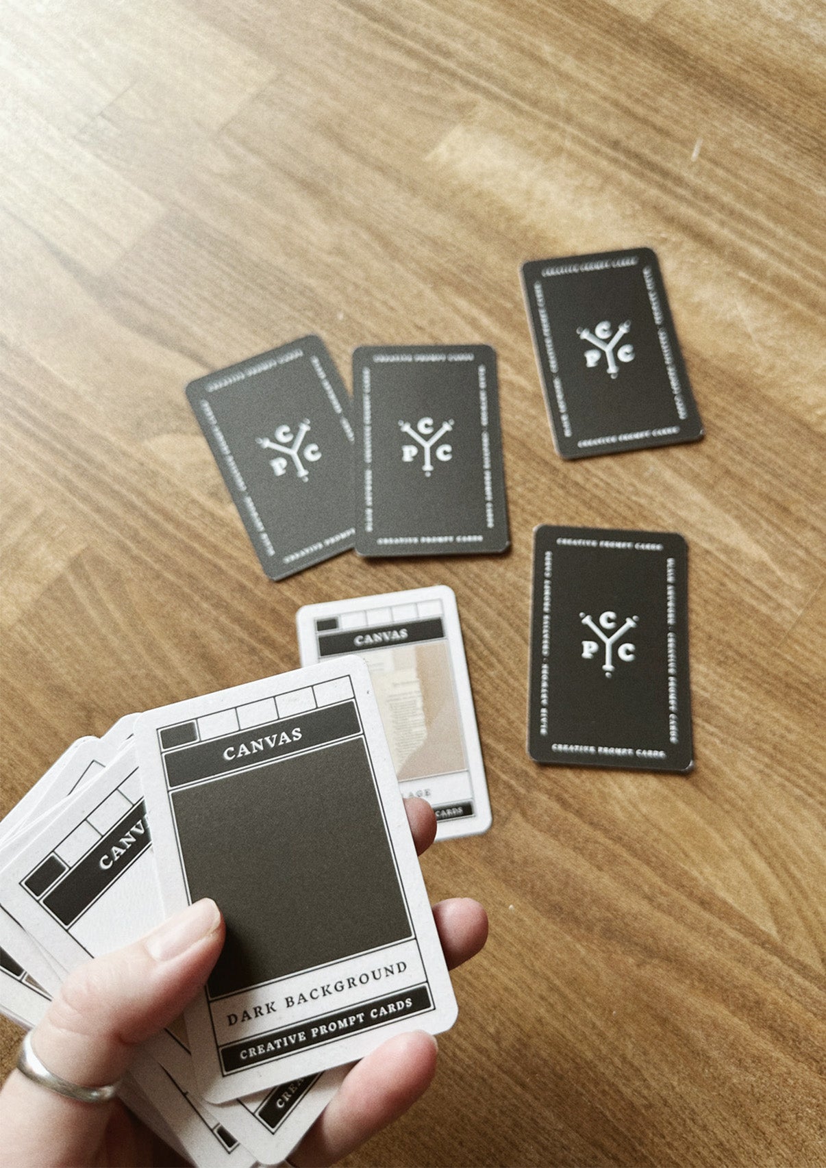 Hand holding cards on a wooden surface