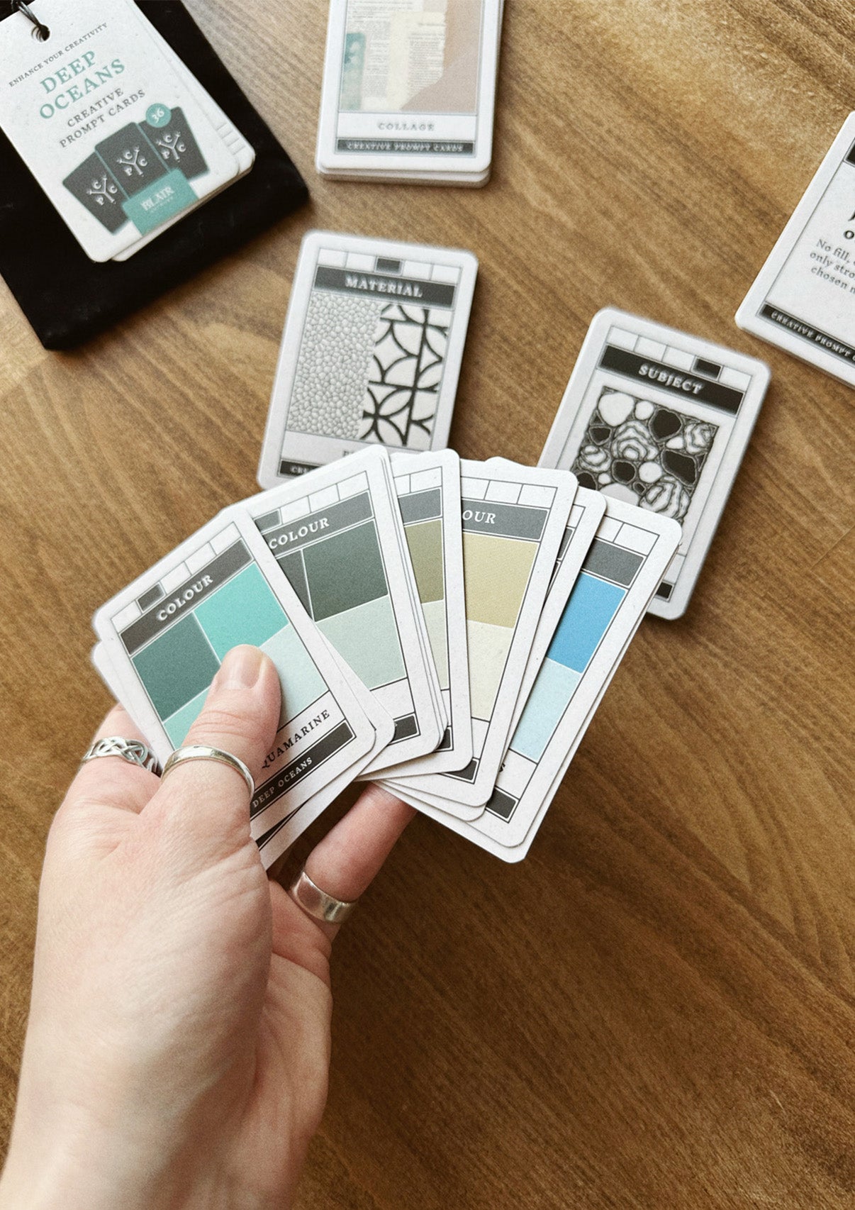 Hand holding cards on wooden surface