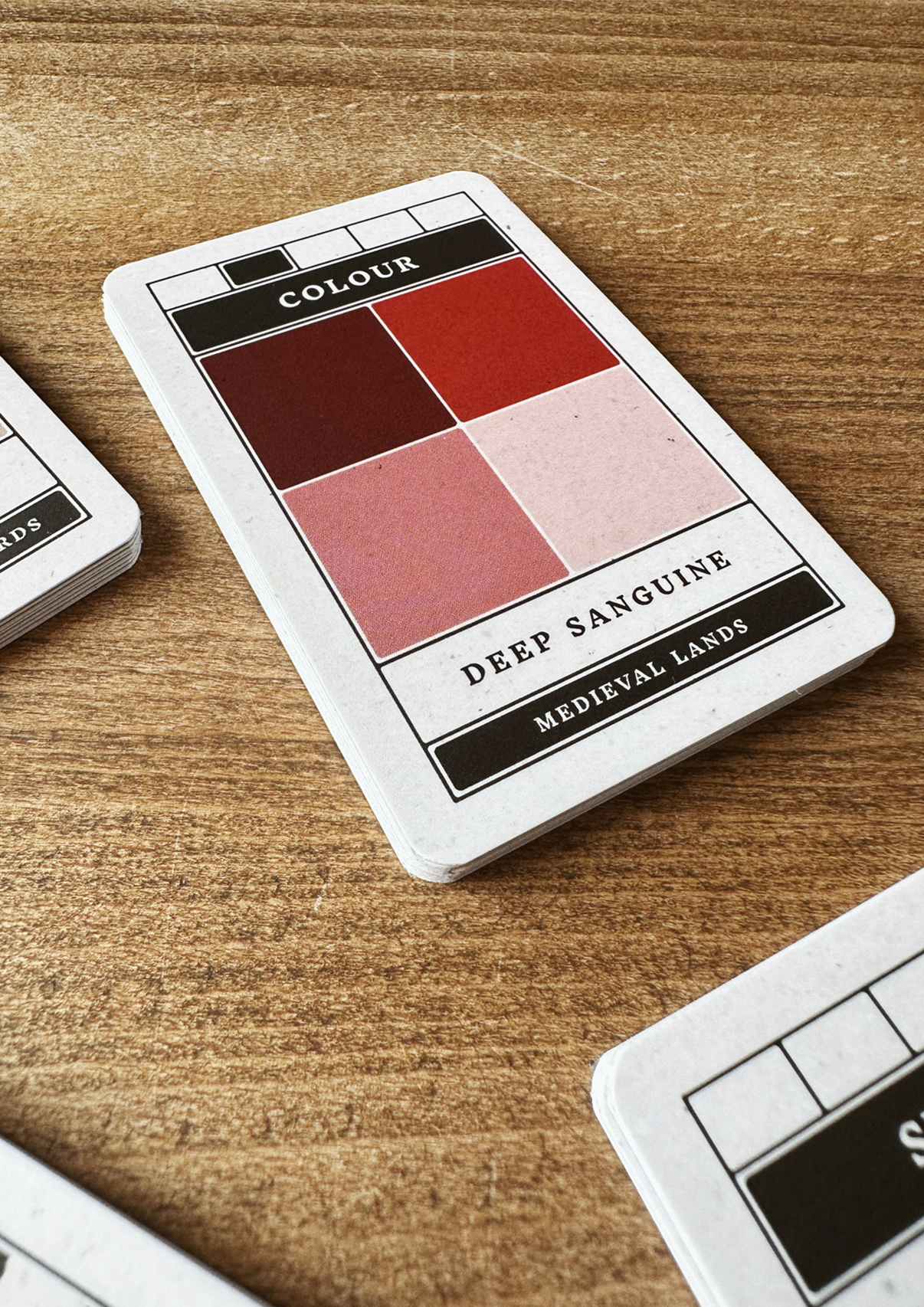 Set of playing cards with illustrations and text on a wooden surface