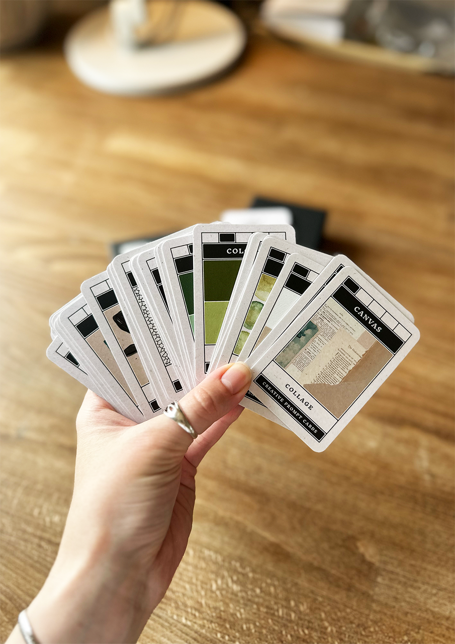 Hand holding a set of cards on a wooden surface