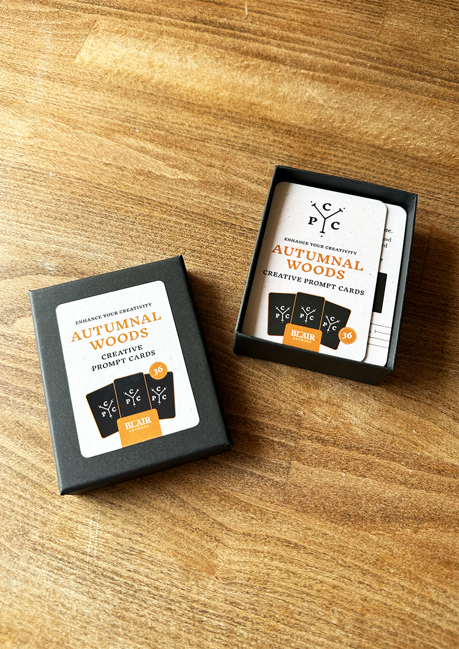 Two boxes of 'Autumnal Woods' creative prompt cards on a wooden surface