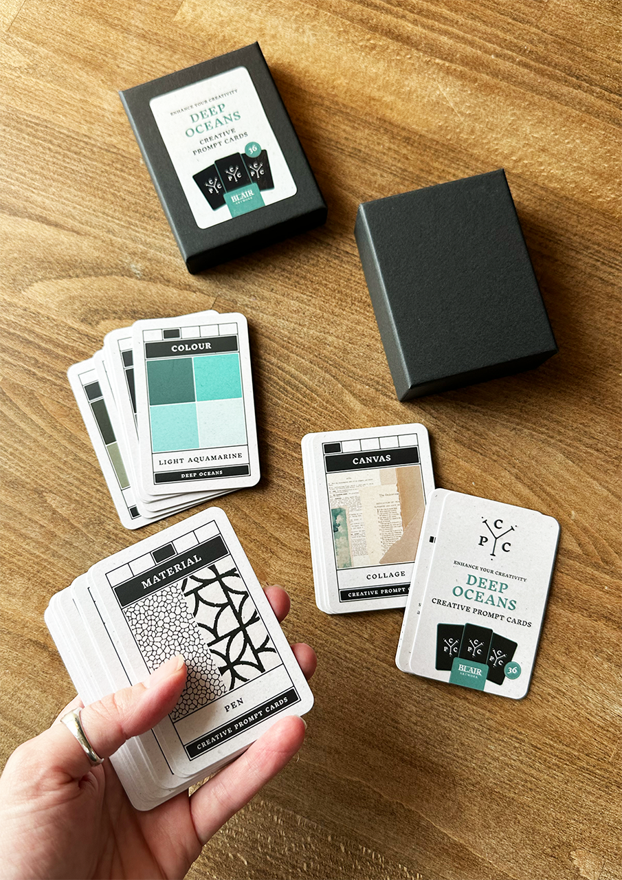 Set of design choice cards on a wooden surface with a hand holding one card.