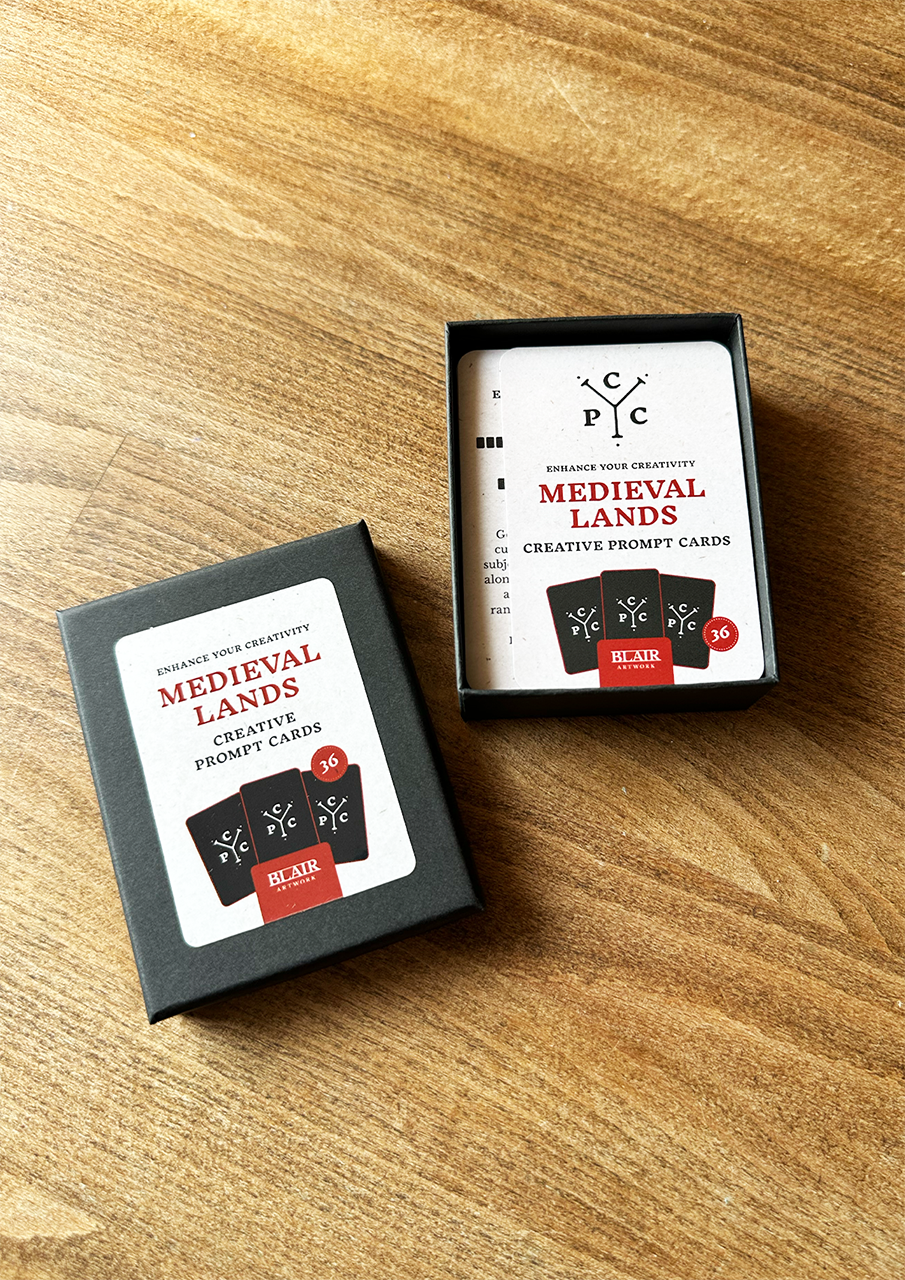 Two boxes of 'Medieval Lands' creative prompt cards on a wooden surface