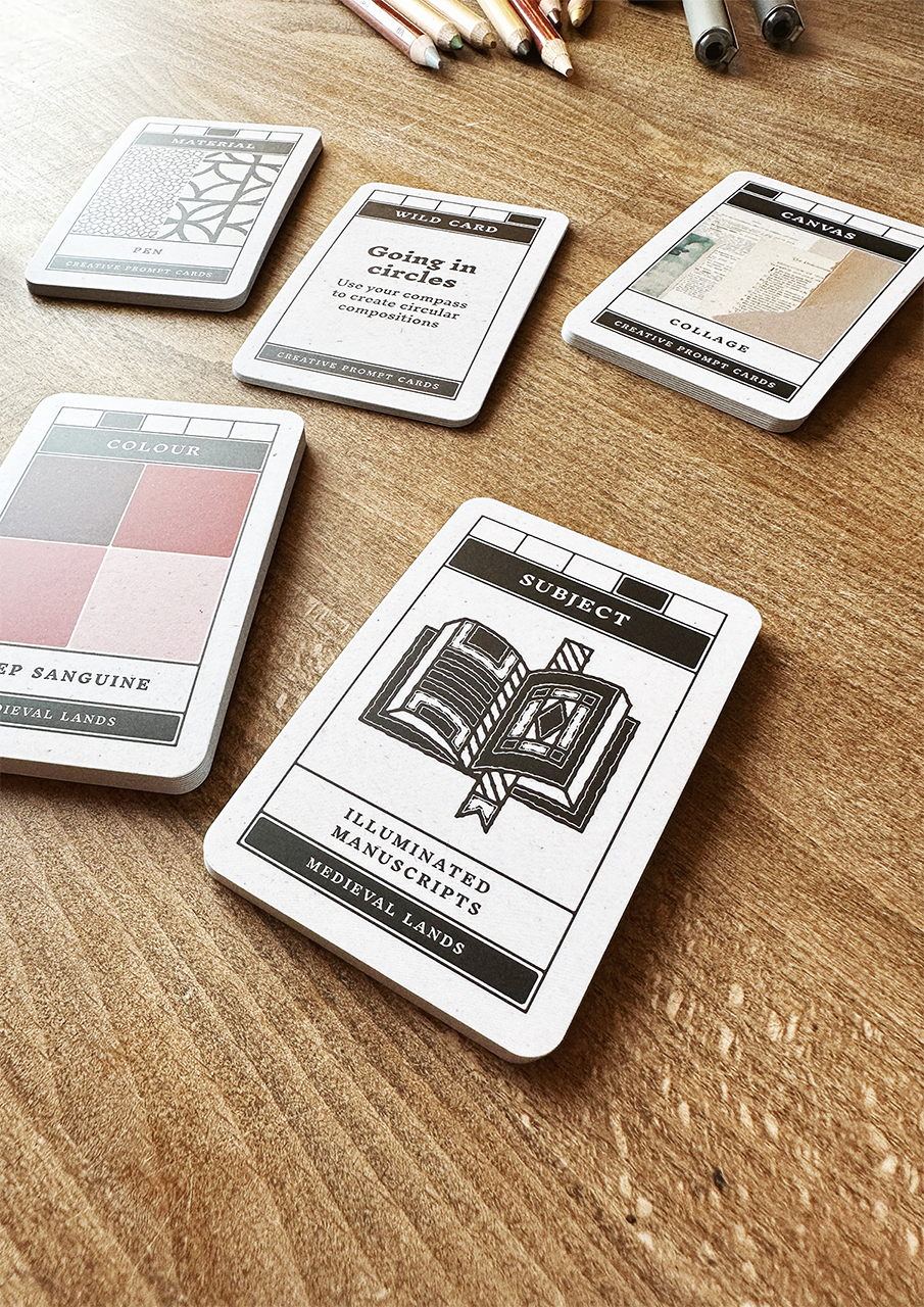Set of playing cards with illustrations and text on a wooden surface