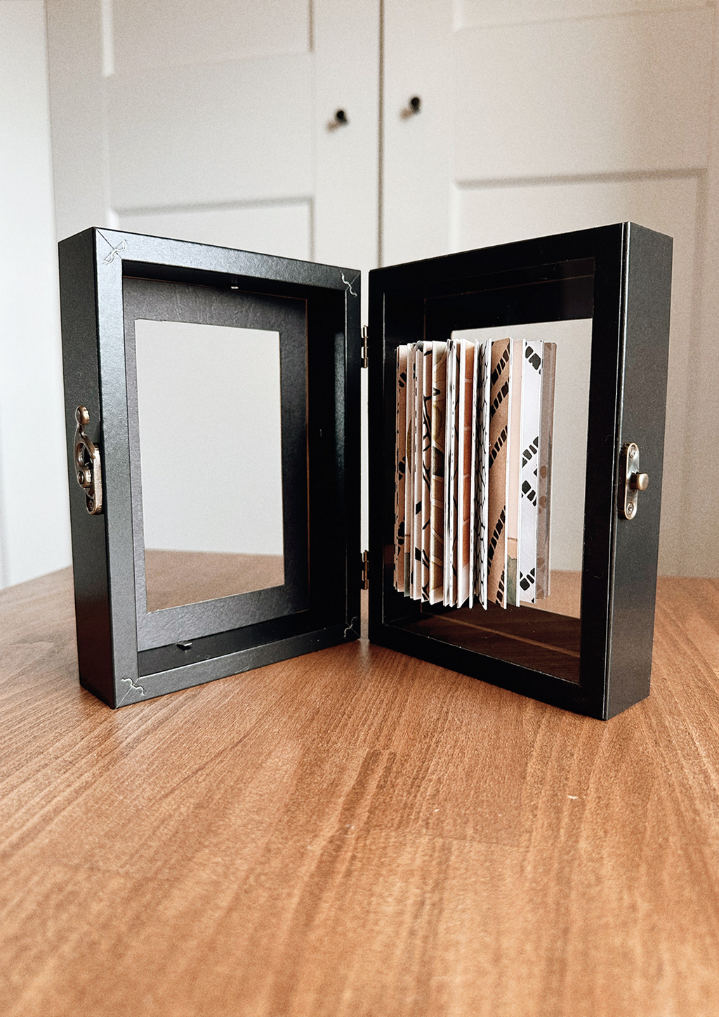 Artwork in open frame on wooden table