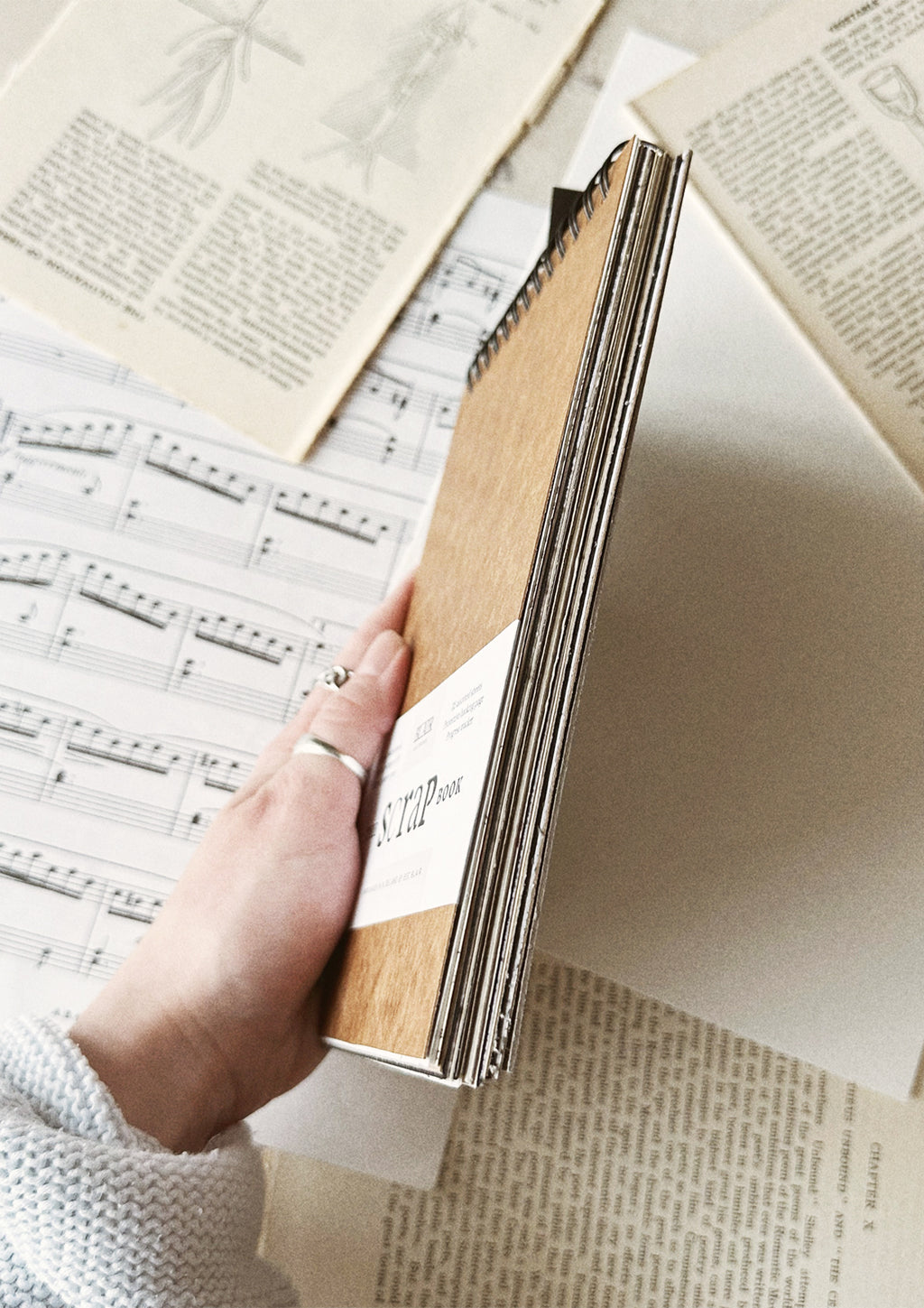 Hand holding book over paper