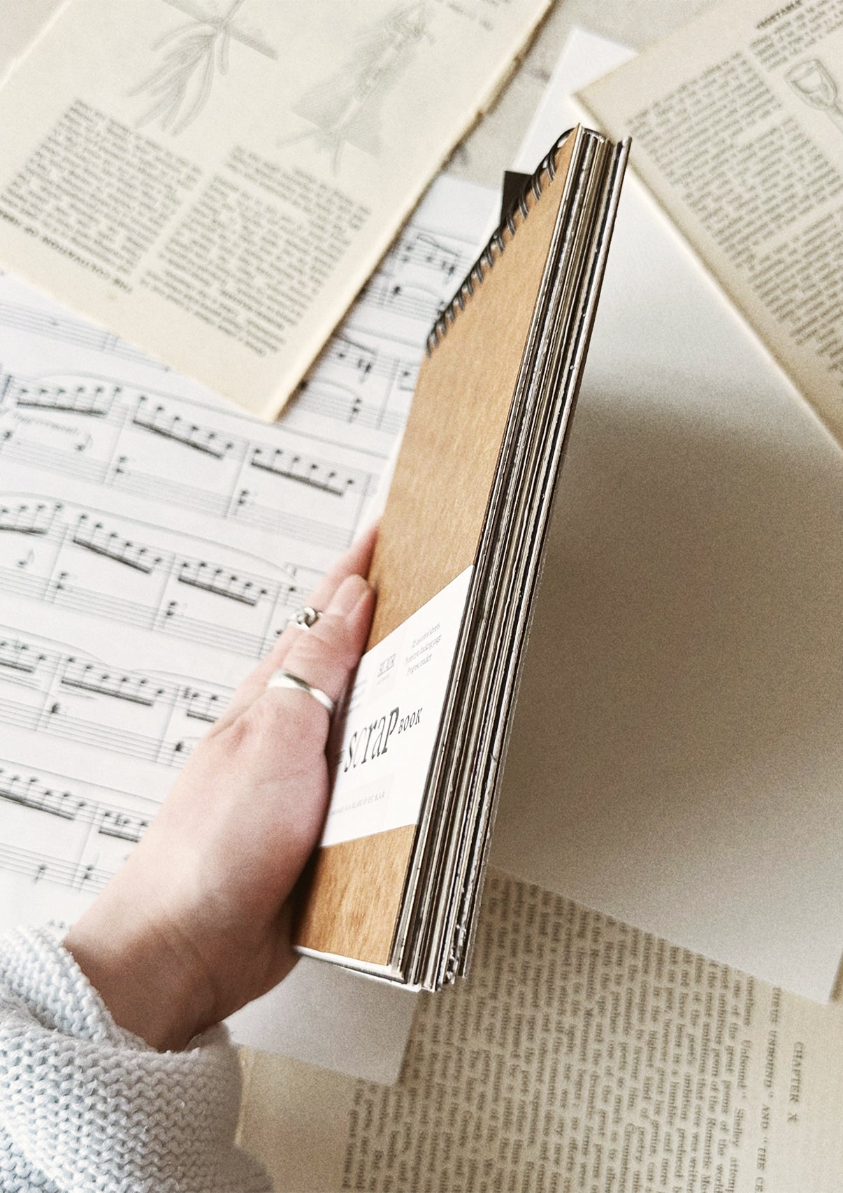 Hand holding book over paper