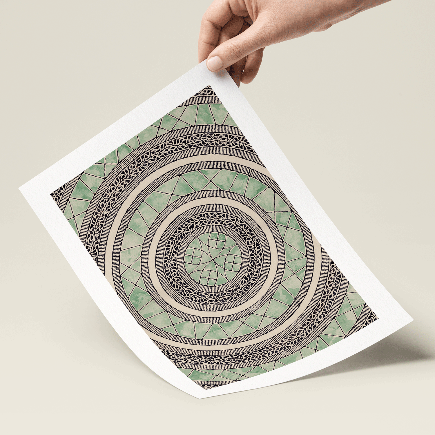Abstract mandala illustration in green and black print in hand