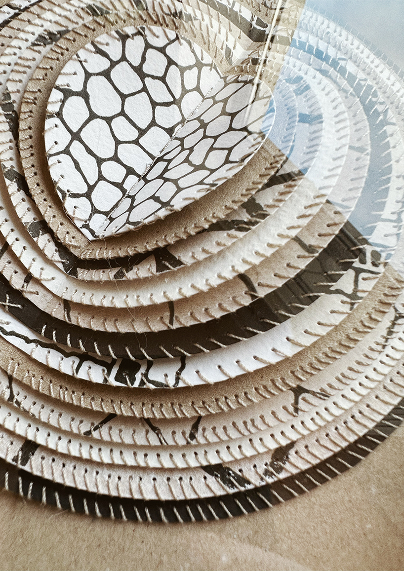 A framed hand-stitched artwork depicting a large circular paper moon.