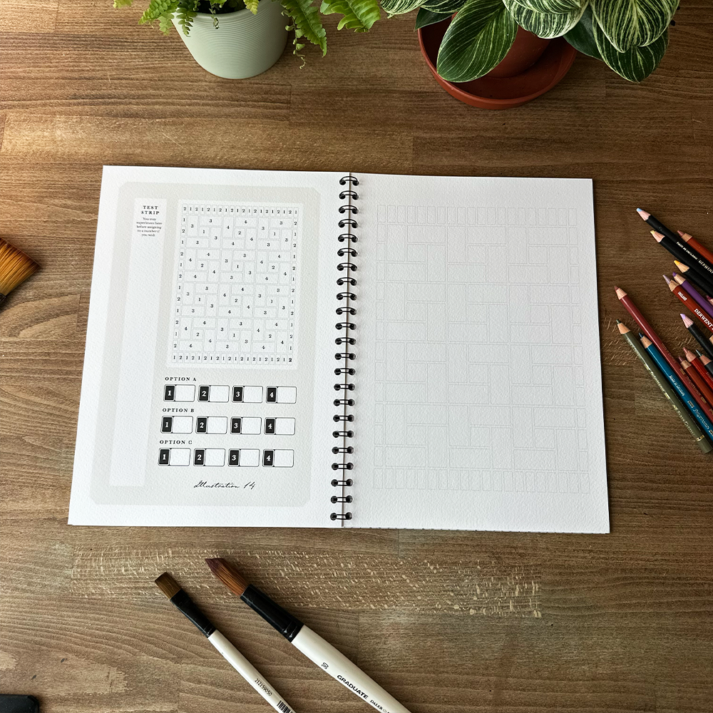 Open notebook on a wooden table with stationery items and plants
