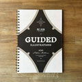Spiral-bound notebook with 'Blair Artwork' guided illustrations on a wooden surface