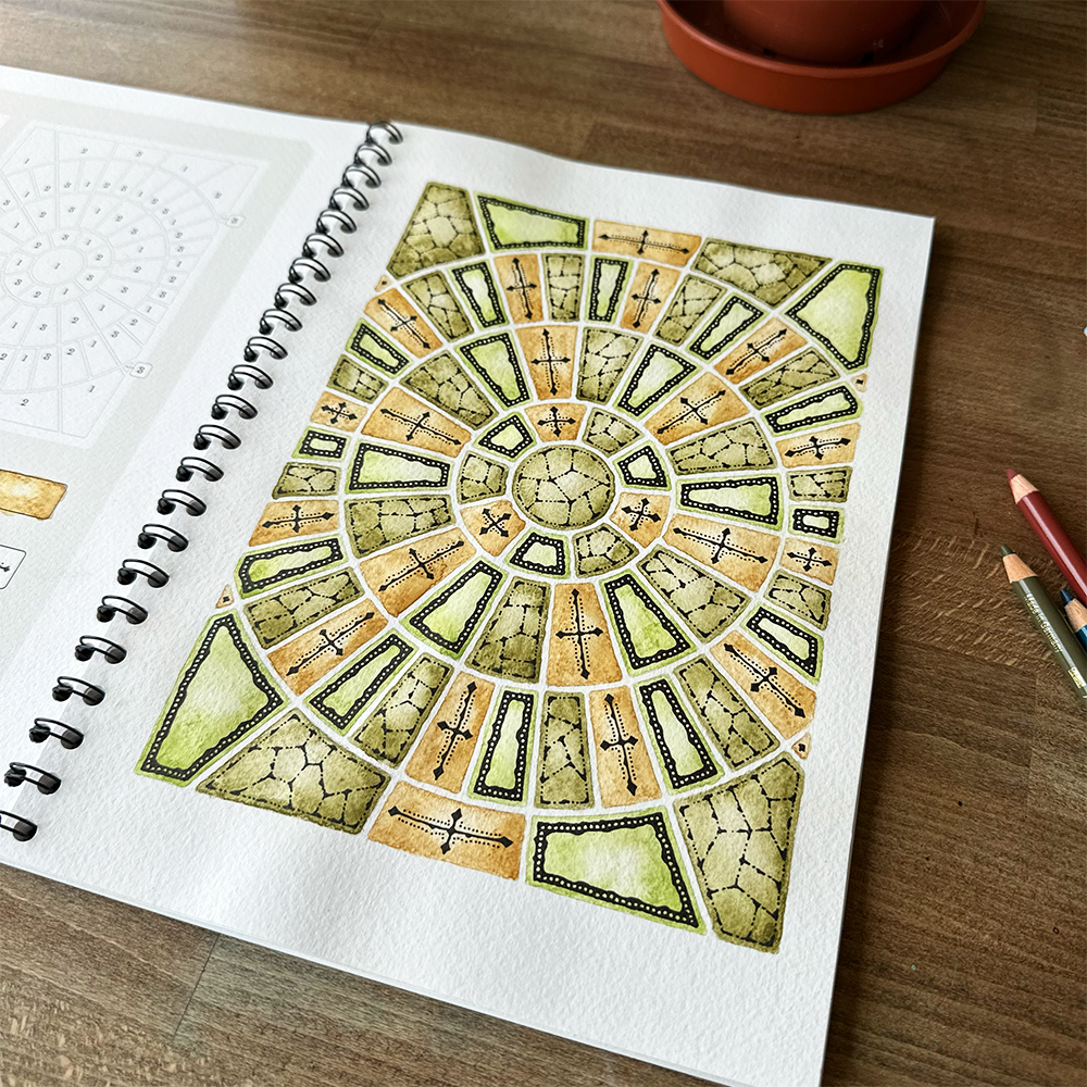 Spiral-bound notebook with a mandala design on a wooden surface