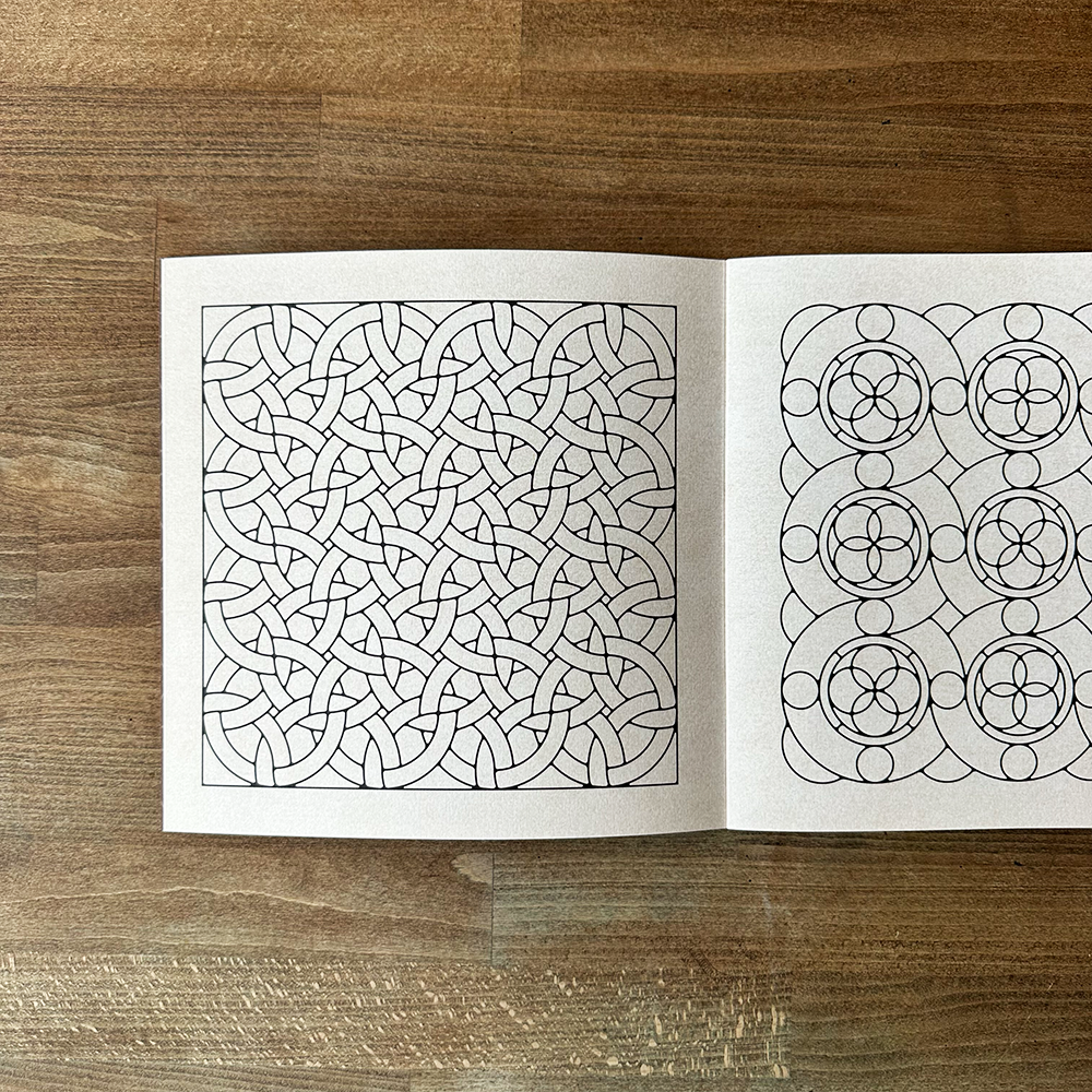 Open book with geometric design on a wooden surface