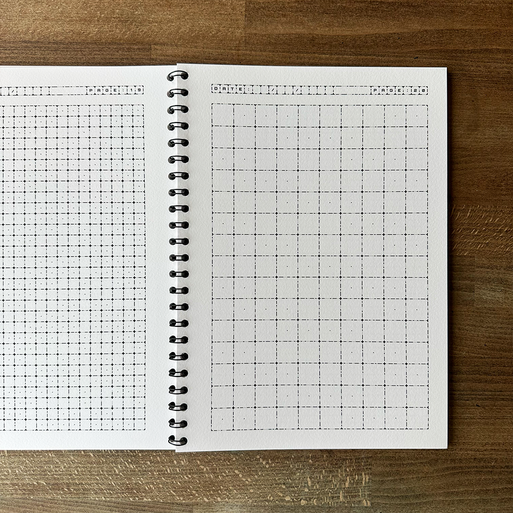 Open notebook with grid paper on a wooden surface
