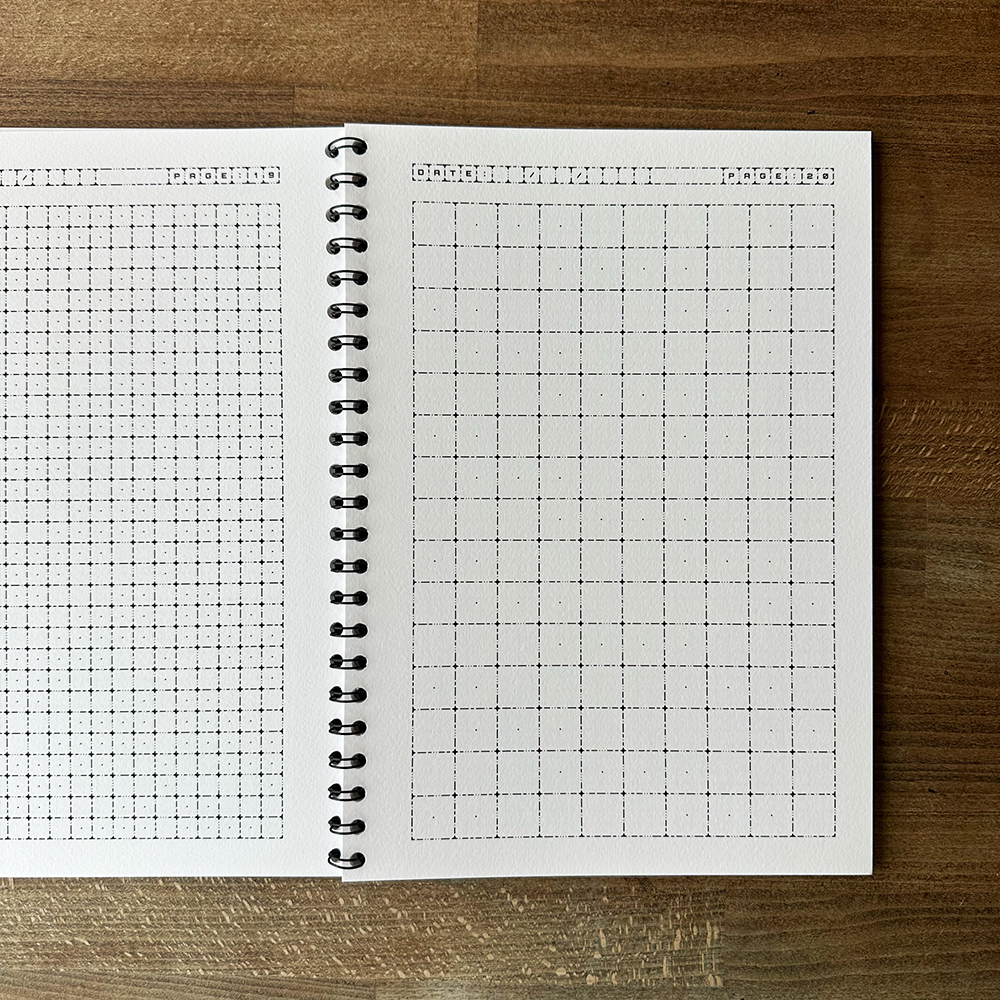 Open notebook with grid paper on a wooden surface