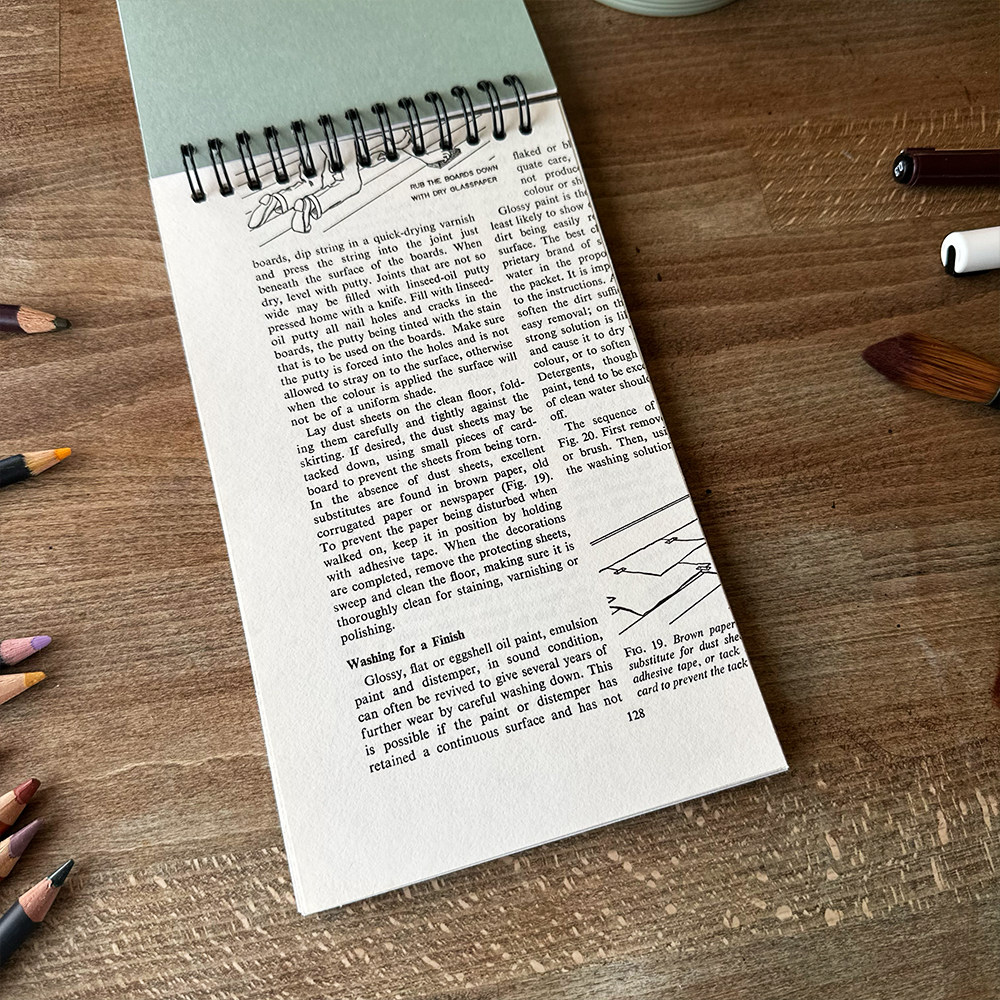 Open book on a wooden surface with writing and illustrations.