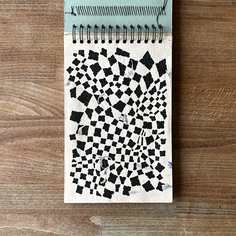 Notebook with black and white pattern on wooden surface