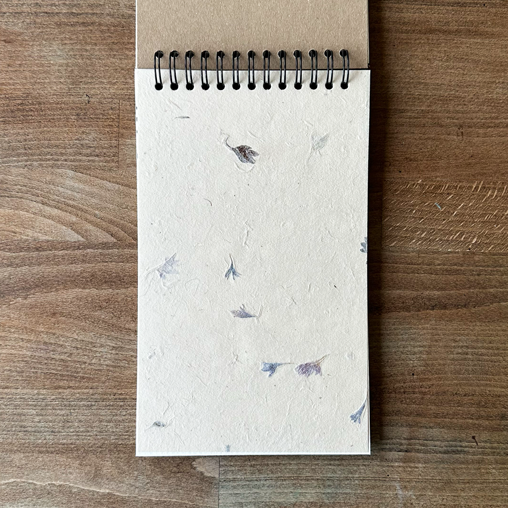 Notebook with floral paper on a wooden surface