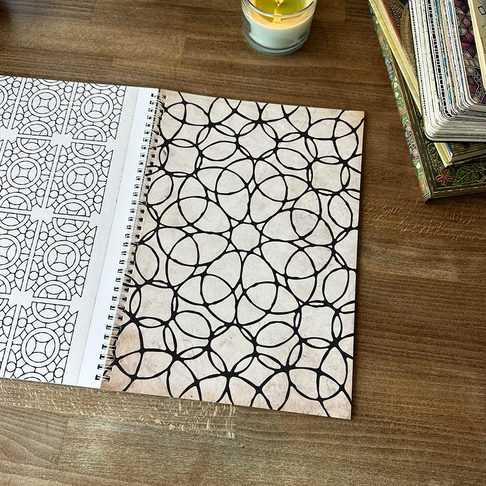 Colouring book with geometric patterns on a wooden surface.