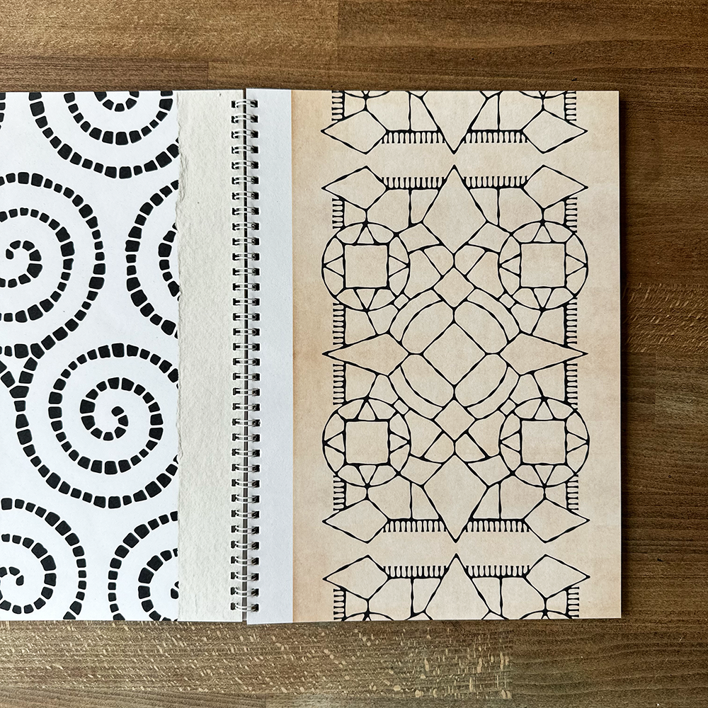 Open book with geometric patterns on a wooden surface