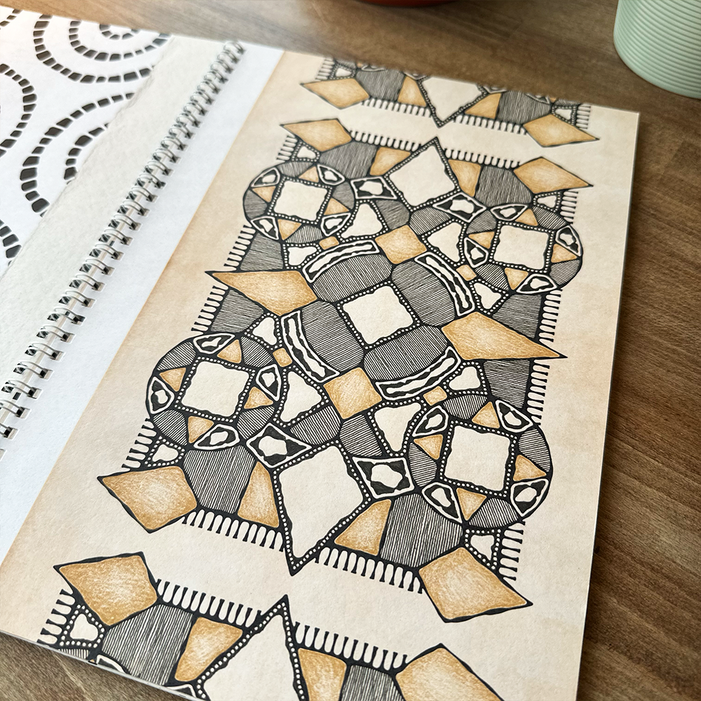 Doodled geometric pattern on a notebook page with a wooden surface in the background