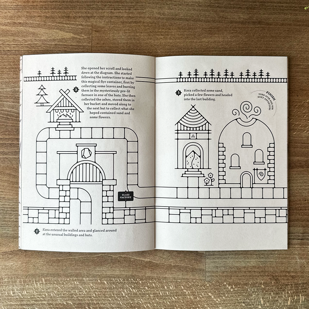 Open book with black and white architectural illustrations on a wooden surface