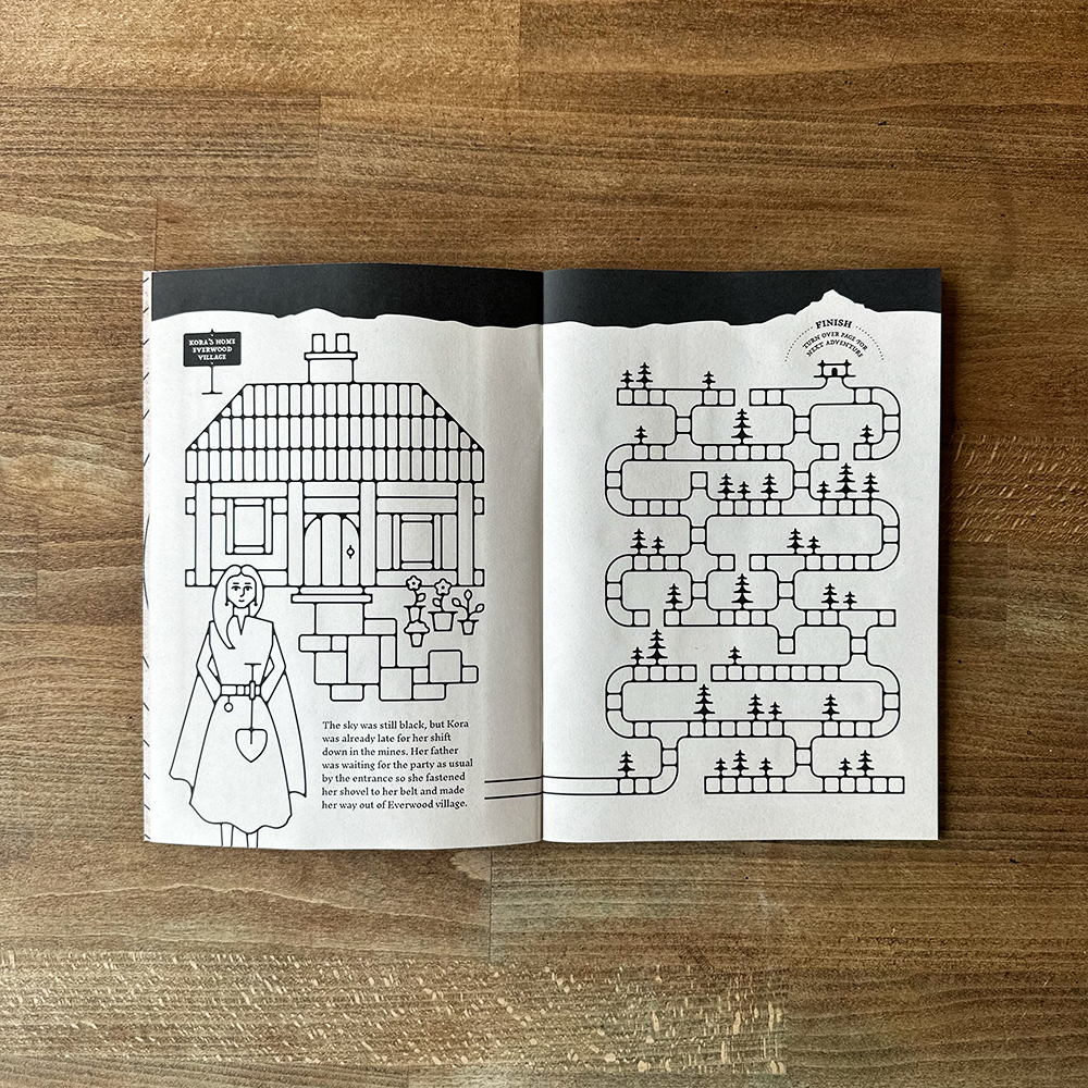 Open book with black and white illustrations on a wooden surface