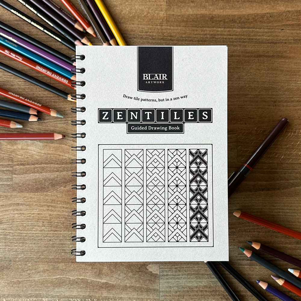 Zentiles guided drawing book by Blair Artworks on a wooden surface with colored pencils.