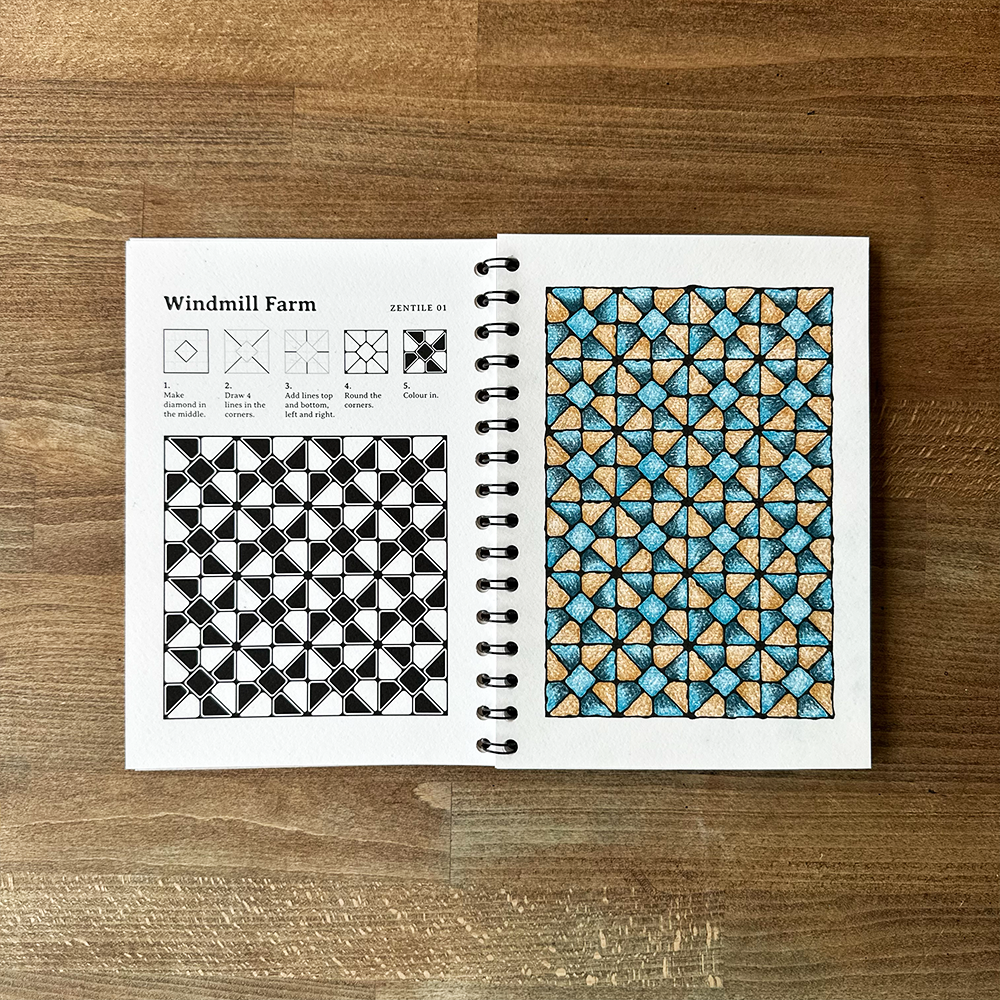 Open notebook with geometric pattern design on a wooden surface